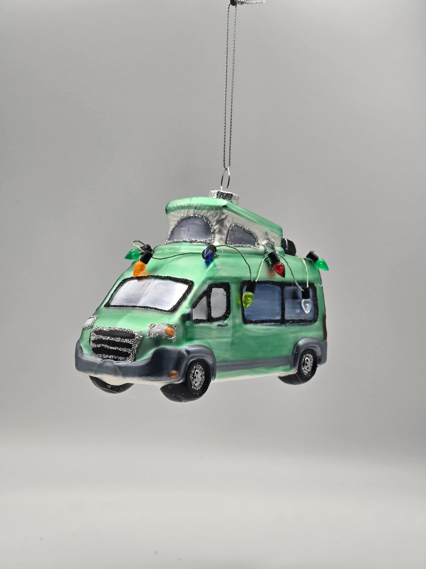 Camper mit Aufstelldach und Lichterkette grün-türkis Vanlife