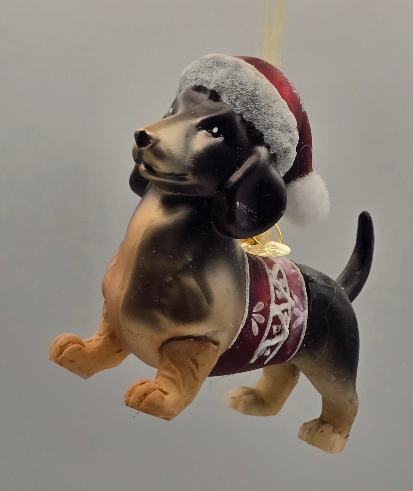 Dackel Mischling mit rotem Pullover und Weihnachtsmann Mütze